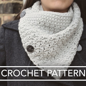 May include: A close-up of a silver crochet cowl with black buttons. The cowl is worn by a person and the text "CROCHET PATTERN" is visible at the bottom of the image.