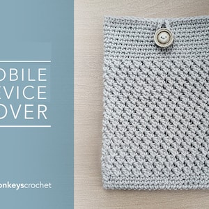 May include: A grey crocheted mobile device cover with a button fastening. The cover is made with a textured stitch pattern. The text "MOBILE DEVICE COVER" is visible in the image.