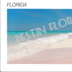 May include: A postcard featuring a beach scene with a starfish on the sand. The sky is blue and the water is turquoise. The text "DESTIN FLORIDA" is superimposed on the image.
