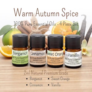 May include: A 4-piece set of 2ml essential oils labeled Warm Autumn Spice, 100% Pure Essential Oils. The bottles are labeled Bergamot, Cinnamon, Sweet Orange, and Vanilla. Each bottle has a black cap and a white label with black text.