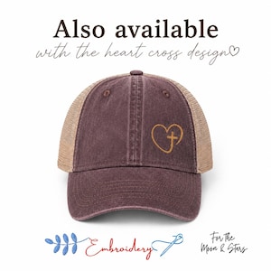 Pu&ograve; includere: Cappellino da camionista bordeaux con retro in rete beige. La parte anteriore del cappellino presenta un design ricamato in oro a forma di cuore e croce. Il testo "Also available with the heart cross design" &egrave; sopra.