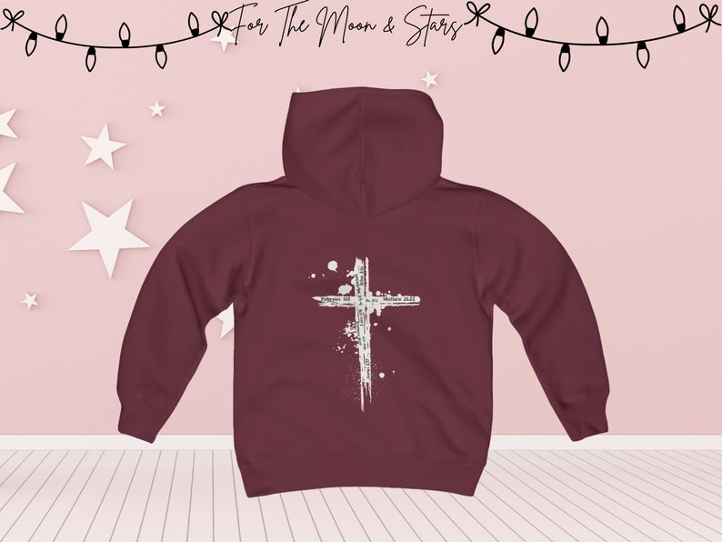 Puede incluir: Sudadera con capucha color burdeos con un gr&aacute;fico de cruz blanca y el texto "Forgive us all, as we forgive those who trespass against us. Matthew 6:12".