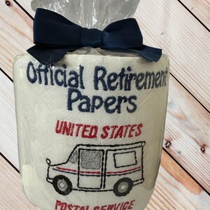 Pu&ograve; includere: Un regalo originale di carta igienica avvolto in cellophane e legato con un fiocco blu navy. Il rotolo &egrave; ricamato con le parole "Official Retirement Papers", una grafica di camion postale e "United States Postal Service".