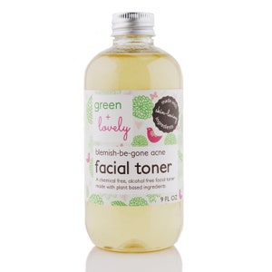 May include: A clear glass bottle with a silver cap, filled with a yellow liquid. The label reads "green + lovely" and "blemish-be-gone acne facial toner." The bottle contains 9 fl oz of product and is made with plant-based ingredients.