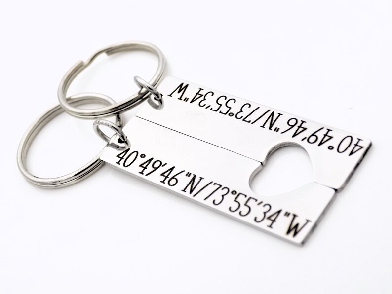 May include: A silver keychain with two tags. The top tag has the coordinates 40&deg;49&prime;46&Prime;N/73&deg;55&prime;34&Prime;W engraved on it. The bottom tag has the coordinates 40&deg;49&prime;46&Prime;N/73&deg;55&prime;34&Prime;W engraved on it.