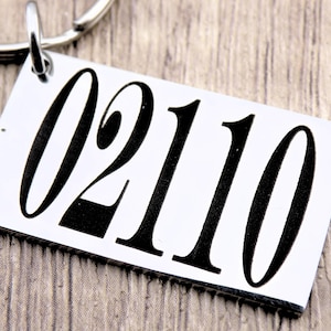May include: Silver keyring with the number 02110 printed in black.
