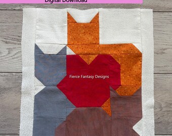 Könnte beinhalten: Ein Patchwork-Quilt-Block mit einem Katzen- und Herz-Design. Der Block besteht aus Stoffen in Orange, Rot, Grau und Braun. Der Text "Cat with Heart Quilt Block Pattern Version 3" steht oben. Die unfertige Größe beträgt 31,75 cm x 31,75 cm.