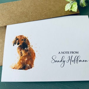 May include: A white card with a watercolor painting of a brown dachshund dog. The text "A Note From Sandy Hoffman" is printed in black at the bottom of the card.