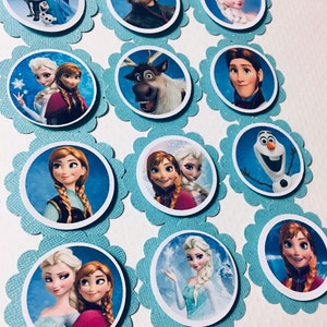 Puede incluir: Doce adornos redondos para cupcakes con personajes de la pel&iacute;cula animada Frozen. Los adornos est&aacute;n impresos en papel blanco y tienen un fondo azul con purpurina. Los personajes incluyen a Elsa, Anna, Kristoff, Olaf, Sven y Hans.