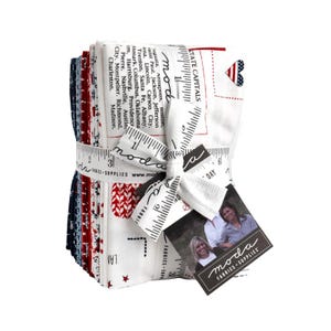 May include: A bundle of Moda Fabrics, featuring red, white, and blue patterned fabric squares. The fabric is tied with a ribbon printed with ruler markings and the Moda Fabrics logo. A tag with the Moda Fabrics logo and two women is attached.