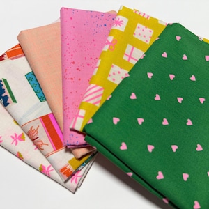 May include: A collection of six folded fabric swatches arranged in a fan shape. The patterns include a green fabric with small pink hearts, a yellow fabric with white gift boxes, a pink fabric with speckles, a solid peach fabric, and white fabrics with colorful gift box and floral motifs.