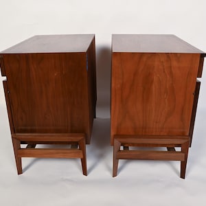 Puede incluir: Dos mesitas de noche de madera a juego con un acabado marr&oacute;n intenso. Cada mesita tiene un dise&ntilde;o rectangular, un caj&oacute;n y una estructura de patas &uacute;nica. La veta de la madera es visible, lo que a&ntilde;ade a la est&eacute;tica natural.