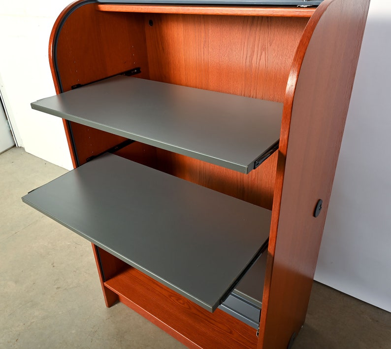May include: A wooden cabinet with two pull-out shelves. The shelves are gray and the cabinet is a reddish-brown color.