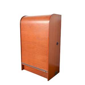May include: A wooden cabinet with a curved top and a sliding door. The cabinet is a reddish-brown color and has a black trim around the door.
