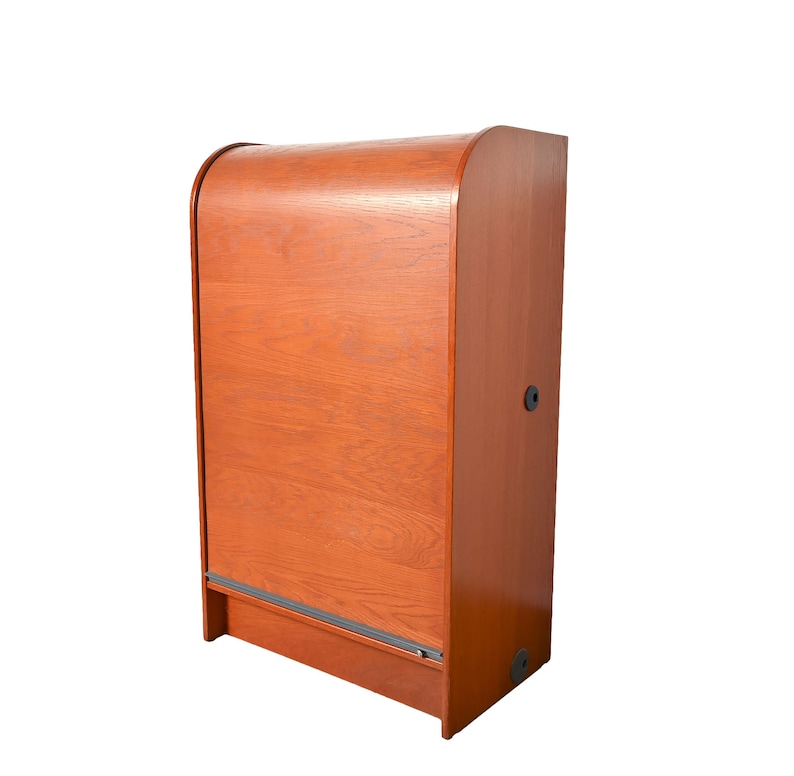 May include: A wooden cabinet with a curved top and a sliding door. The cabinet is a reddish-brown color and has a black trim around the door.