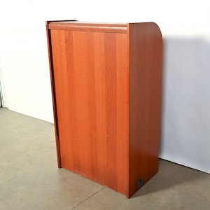 May include: A wooden cabinet with a light brown finish. The cabinet has a single door and a rounded top.
