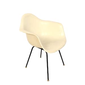 May include: Off-white molded plastic armchair with a curved seat and back. The chair has a black metal base with four legs. The legs have small, round, light-colored feet. The chair is a mid-century modern design.
