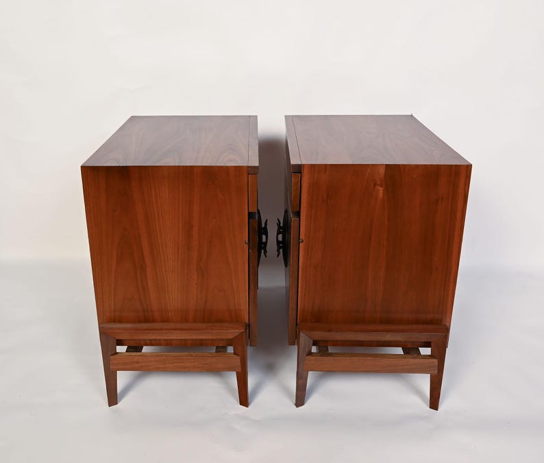 Puede incluir: Dos mesitas de noche de madera a juego con un acabado marr&oacute;n c&aacute;lido. Cada mesita tiene una parte superior rectangular, un solo caj&oacute;n y un estante inferior sostenido por cuatro patas. Las mesitas est&aacute;n una al lado de la otra.