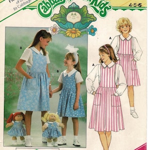 May include: A vintage sewing pattern for Cabbage Patch Kids outfits. The pattern features illustrations of children wearing dresses and aprons. The pattern includes the text "FREE PATTERN" and "YES! IT'S EASY!"