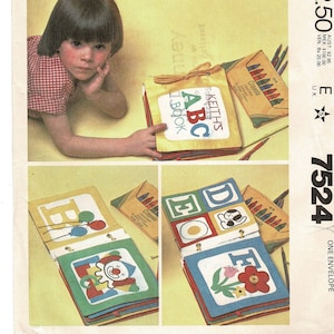 May include: A sewing pattern for a set of three alphabet books. Each book has a different letter on the front cover and a colorful illustration inside. The pattern includes instructions for making the books and a small pouch for storing crayons.