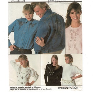 May include: A fashion catalog page featuring various clothing items. A denim jacket and shirt with embroidered details, a pink t-shirt with a rhinestone bow, and a white sweater with a jeweled necklace design are shown. The text reads "Designs for Decorating with Studs or Rhinestones."