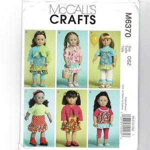 May include: McCall's Crafts sewing pattern M6370 featuring six dolls in various outfits. The dolls are wearing dresses, tops, skirts, and leggings in bright colors. The pattern includes sizes OSZ.
