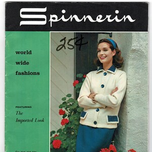 May include: Vintage fashion magazine cover featuring the word "Spinnerin" in white script on a black background. The cover also includes the words "world wide fashions" and "The Imported Look". A woman is wearing a cream-colored jacket with blue accents and a blue skirt.