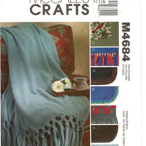 May include: McCall's Crafts M4684 sewing pattern envelope featuring a light blue fleece throw blanket with knotted fringe. The cover displays various blanket styles with decorative edges, including fringe, embroidery, and woven details.