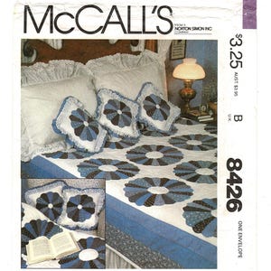 May include: A McCall's pattern envelope featuring a quilt and pillow set. The quilt and pillows have a blue and white floral design. The envelope has the text "McCall's" at the top and the number "8426" on the right side.