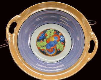 May include: A vintage serving bowl with two handles. The bowl is decorated with a colorful floral design on a white background. The bowl has a light blue rim and a gold rim.