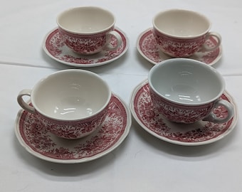 May include: Set of four white teacups and saucers with a pink floral pattern.