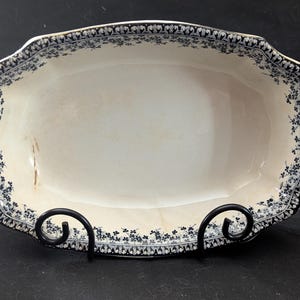 May include: A white oval serving dish with a blue and white floral pattern around the edge.