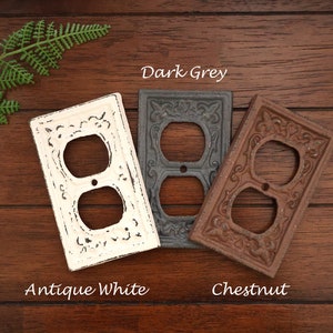 May include: Three outlet covers in different colors: antique white, dark grey, and chestnut. Each cover has a decorative, ornate design.