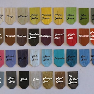 Puede incluir: Una colecci&oacute;n de peque&ntilde;as muestras de color de madera dispuestas en filas. Cada muestra est&aacute; etiquetada con un nombre de color, como "Blanco Antiguo", "Amarillo Lim&oacute;n" y "Azul Oscuro". Las muestras muestran una variedad de tonos, incluyendo verdes, azules, rojos y marrones.