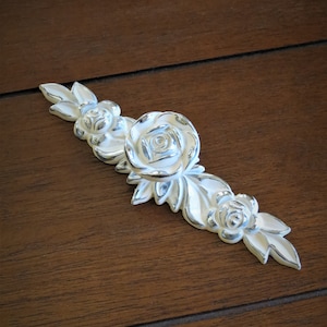 May include: Silver-toned drawer pull with a floral design featuring three roses and leaves.