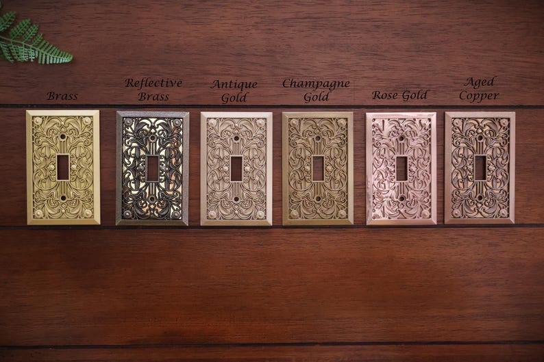 Puede incluir: Seis cubiertas decorativas para interruptores de luz en varios acabados met&aacute;licos: lat&oacute;n, lat&oacute;n reflectante, oro antiguo, oro champ&aacute;n, oro rosa y cobre envejecido. Cada cubierta presenta un dise&ntilde;o floral ornamentado.