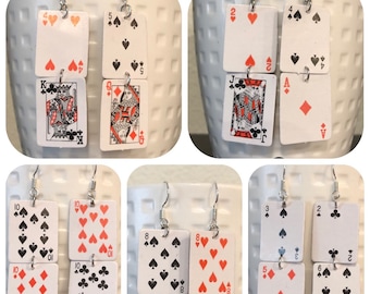 May include: A set of six pairs of earrings featuring playing cards. Each earring is made of two cards, one on top of the other. The cards are in various suits and numbers, including 2, 4, 5, 6, 8, 9, 10, Jack, Queen, King, and Ace.