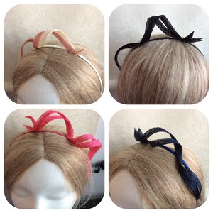 May include: Four headbands made of fabric and wire. The headbands are in different colors: pink, red, black, and cream. The headbands are on mannequins with blonde hair.