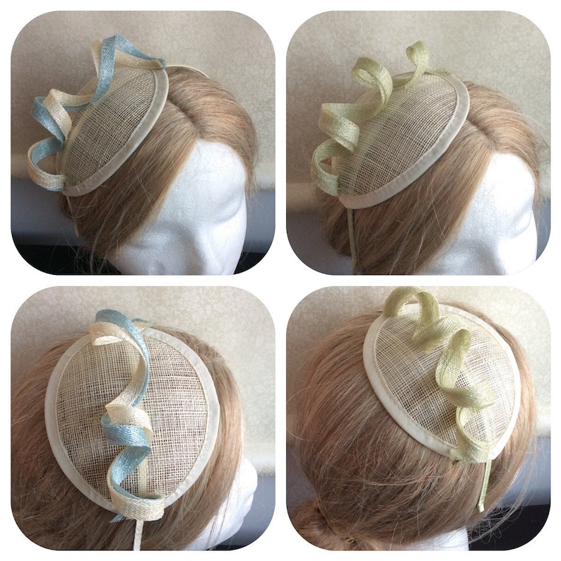 May include: Four images of a small, round, cream-colored hat with a curled ribbon decoration. The ribbon is either blue and white or green and white.