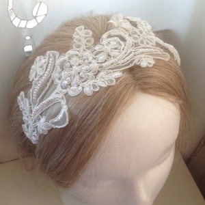 May include: A white lace headband with pearl accents. The headband is delicate and feminine, and would be perfect for a wedding or other special occasion.