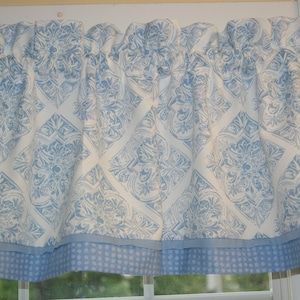 Könnte beinhalten: Ein weißer Volant mit einem blauen und weißen Muster. Der Volant hat einen blauen und weißen Tupfenbesatz.