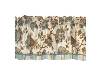 May include: A window valance featuring a cream-colored background with a floral pattern in shades of teal, brown, and tan. The top edge is gathered for a ruffled effect, and the bottom hem is finished with a light blue and white striped border.