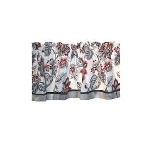 May include: A window valance featuring a white background with a floral pattern in shades of red, grey, and black. The fabric has a gathered top for hanging and a bottom border with a black and white vertical stripe design along the hemline.