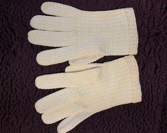 May include: A pair of white knitted gloves. The gloves are made of a delicate, open-weave fabric.