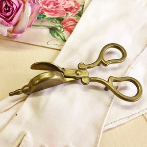 Where can you buy a vintage BRASS CANDLE SNUFFER SciSSors?  Here and it's in GREAT condition and perfect for snuffin' out wicks on candles!  It's so much nicer than burning your fingers. It's FooTeD and has a great gothic or Victorian look and would make a great photography prop.  
I always called this tool a SNUFFEROUTER but did ya know another word for snuffer is Douter? Good vintage condition.