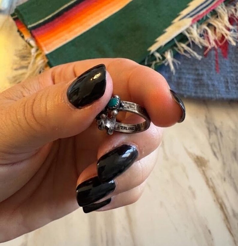 This ZUNI SNAKE EYES RiNG is kinda fabulous.  It came out of a Tucson trading post and is a Fred Harvey era Treasure!  It's sterling and has 5 turquoise snake eyes.  Tiny round raindrops adorn  the sides of the ring.  Size 4-1/2.  Original patina left.

ZUNI SNAKE EYES is a masterful lapidary style originally developed by Zuni Pueblo artists around the 1930s and 1940s. It's one of the most incredibly labor-intensive and meticulous techniques in Native American jewelry making.