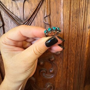 This ZUNI SNAKE EYES RiNG is kinda fabulous.  It came out of a Tucson trading post and is a Fred Harvey era Treasure!  It's sterling and has 5 turquoise snake eyes.  Tiny round raindrops adorn  the sides of the ring.  Size 4-1/2.  Original patina left.

ZUNI SNAKE EYES is a masterful lapidary style originally developed by Zuni Pueblo artists around the 1930s and 1940s. It's one of the most incredibly labor-intensive and meticulous techniques in Native American jewelry making.