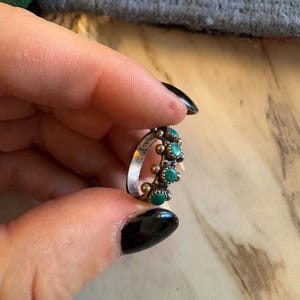 This ZUNI SNAKE EYES RiNG is kinda fabulous.  It came out of a Tucson trading post and is a Fred Harvey era Treasure!  It's sterling and has 5 turquoise snake eyes.  Tiny round raindrops adorn  the sides of the ring.  Size 4-1/2.  Original patina left.

ZUNI SNAKE EYES is a masterful lapidary style originally developed by Zuni Pueblo artists around the 1930s and 1940s. It's one of the most incredibly labor-intensive and meticulous techniques in Native American jewelry making.