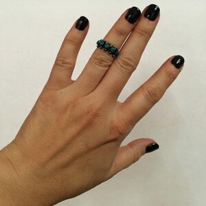 This ZUNI SNAKE EYES RiNG is kinda fabulous.  It came out of a Tucson trading post and is a Fred Harvey era Treasure!  It's sterling and has 5 turquoise snake eyes.  Tiny round raindrops adorn  the sides of the ring.  Size 4-1/2.  Original patina left.

ZUNI SNAKE EYES is a masterful lapidary style originally developed by Zuni Pueblo artists around the 1930s and 1940s. It's one of the most incredibly labor-intensive and meticulous techniques in Native American jewelry making.