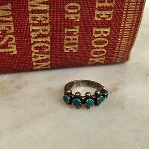 This ZUNI SNAKE EYES RiNG is kinda fabulous.  It came out of a Tucson trading post and is a Fred Harvey era Treasure!  It's sterling and has 5 turquoise snake eyes.  Tiny round raindrops adorn  the sides of the ring.  Size 4-1/2.  Original patina left.

ZUNI SNAKE EYES is a masterful lapidary style originally developed by Zuni Pueblo artists around the 1930s and 1940s. It's one of the most incredibly labor-intensive and meticulous techniques in Native American jewelry making.